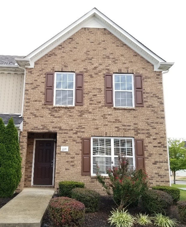 a front view of a house with a garden