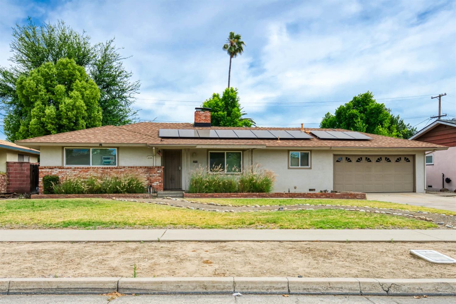 a front view of a house with a garden and yard