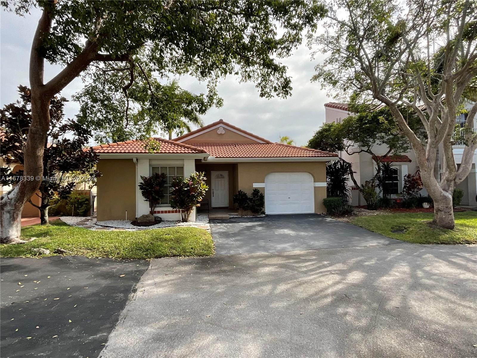 a view of a house with a yard and large tree