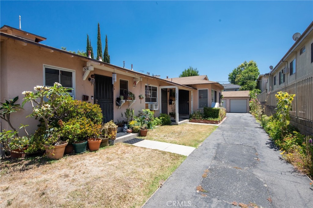 a front view of a house with a yard and potted plants