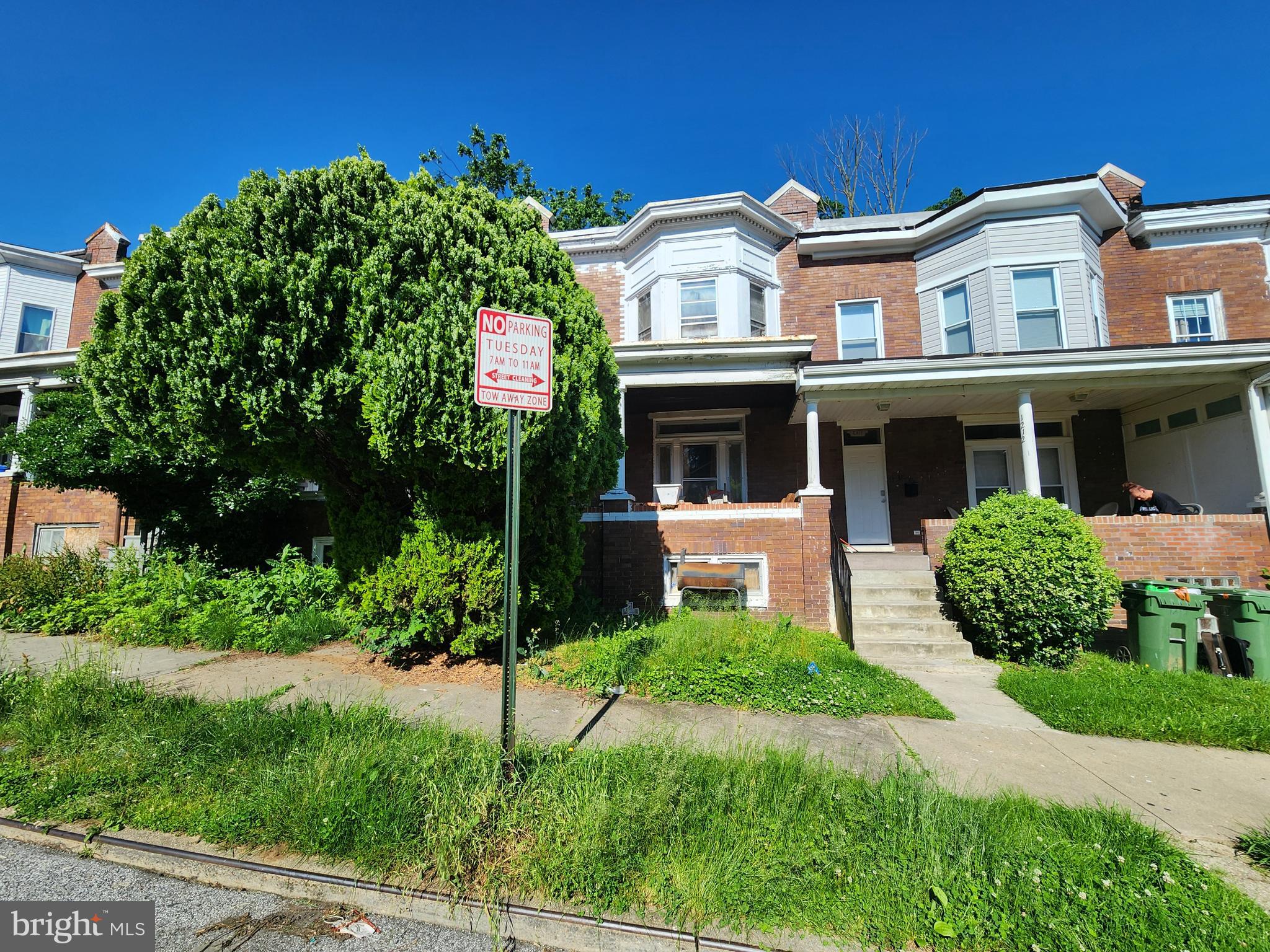 a front view of a house with a yard and potted plants