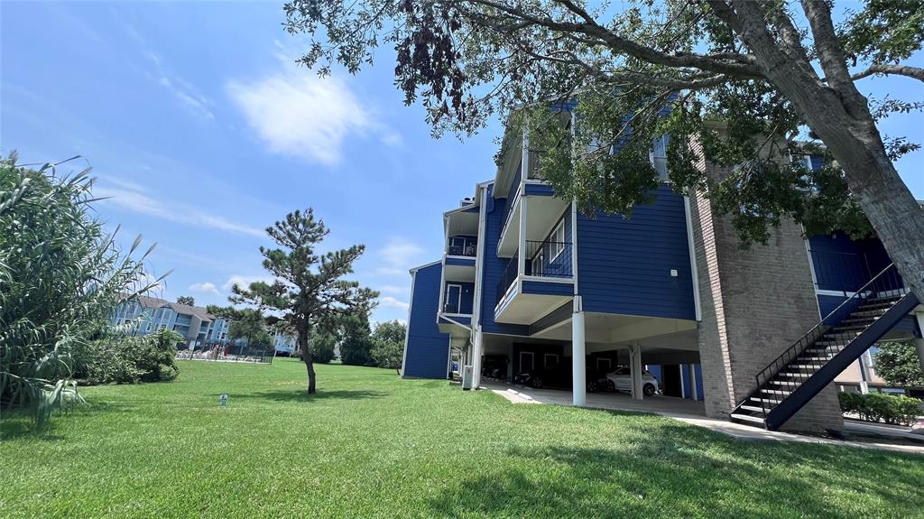 a view of an house with backyard and a tree