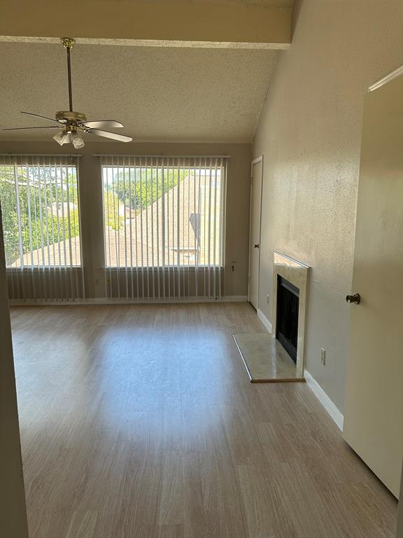 an empty room with wooden floor and fireplace