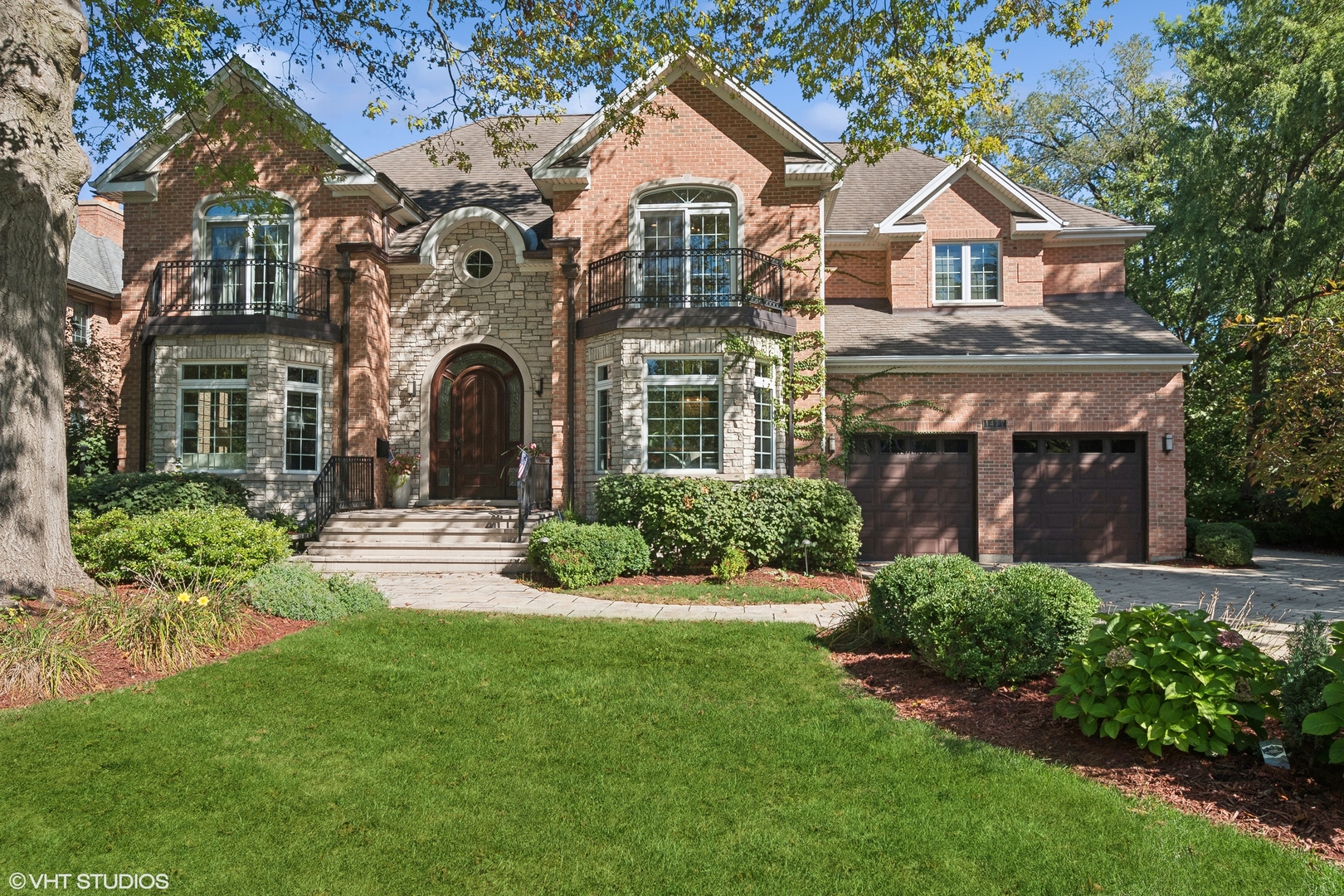 a front view of a house with a yard and potted plants