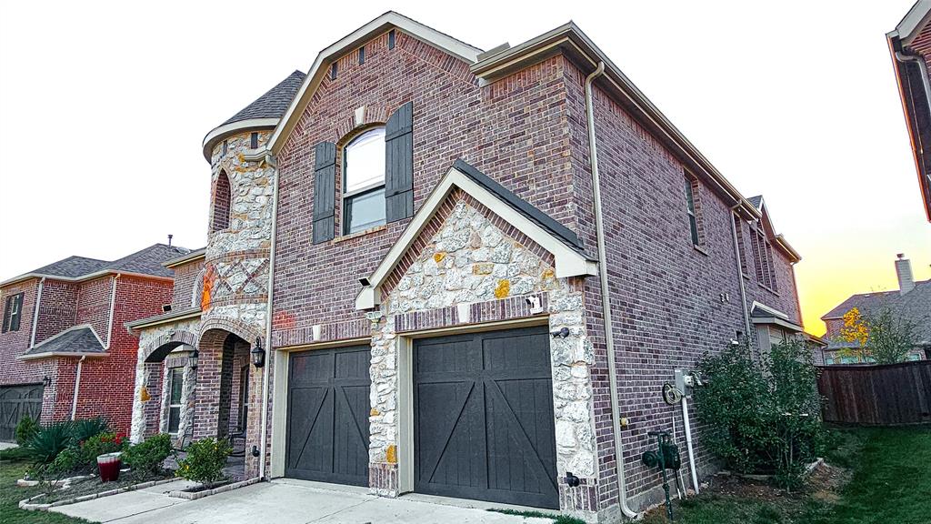 a view of a brick house next to a yard