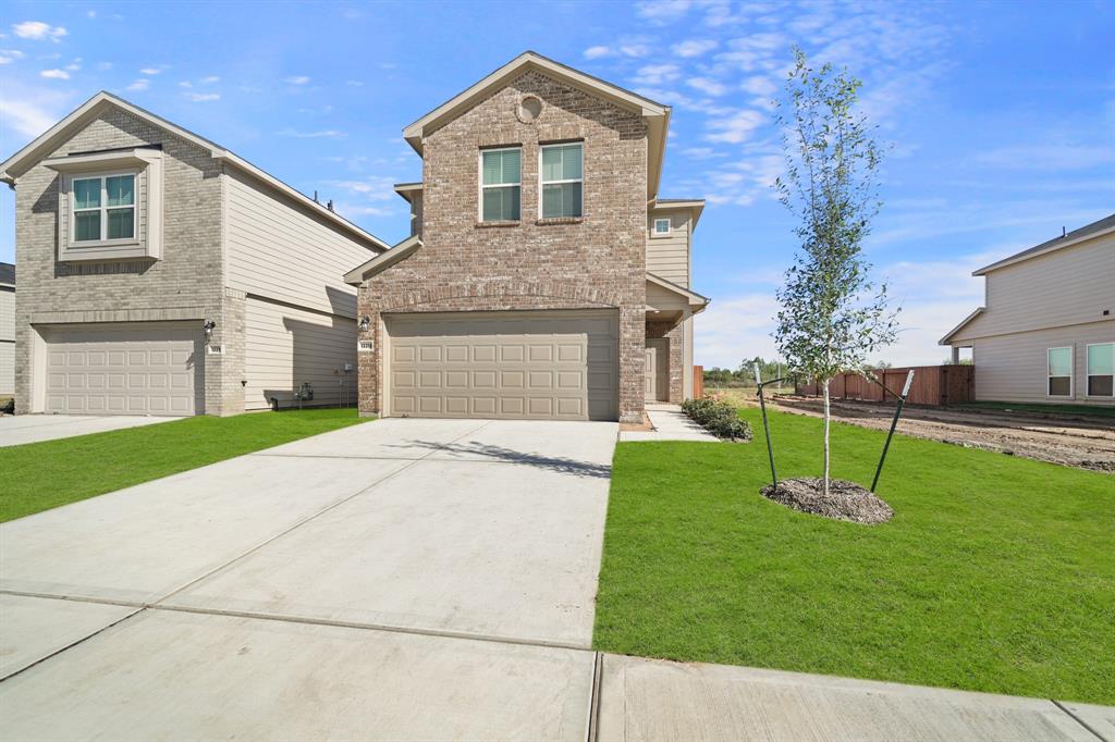 a front view of a house with a yard and garage