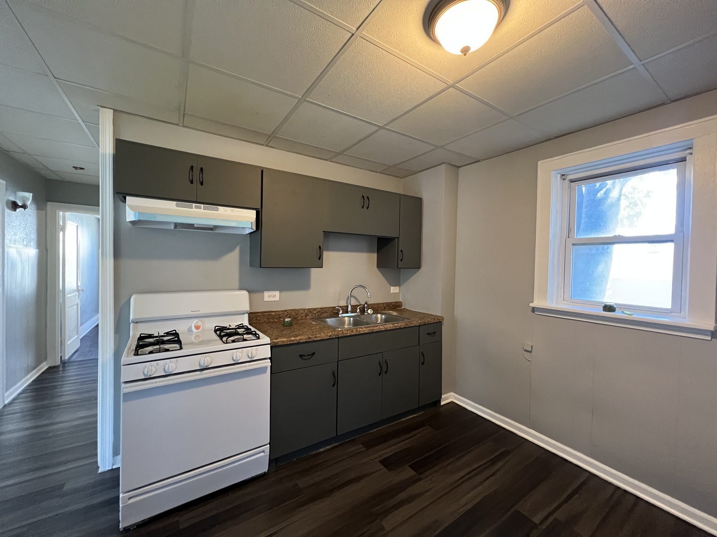 a kitchen with granite countertop a stove and a wooden floor