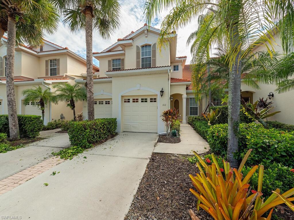 front view of a house with a yard and palm trees