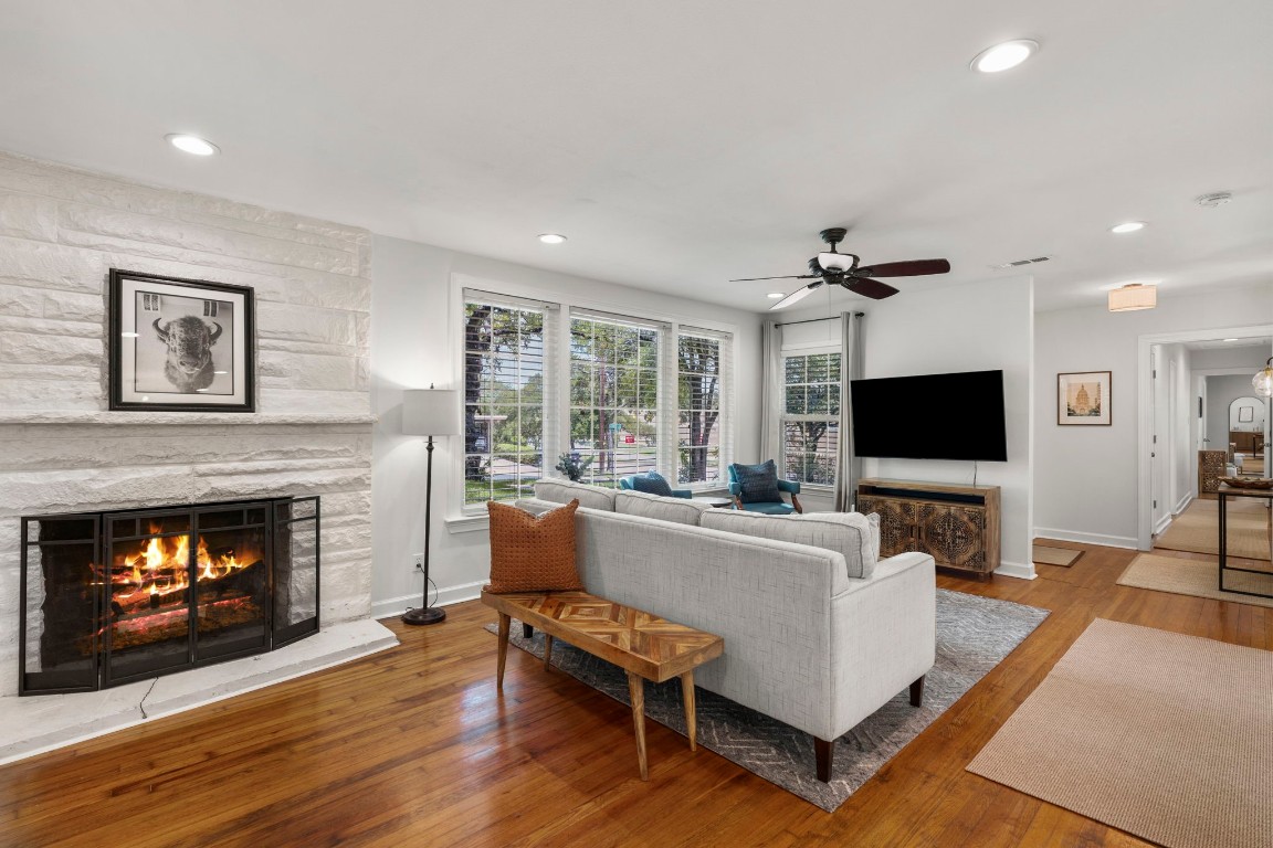 a living room with furniture a flat screen tv and a fireplace