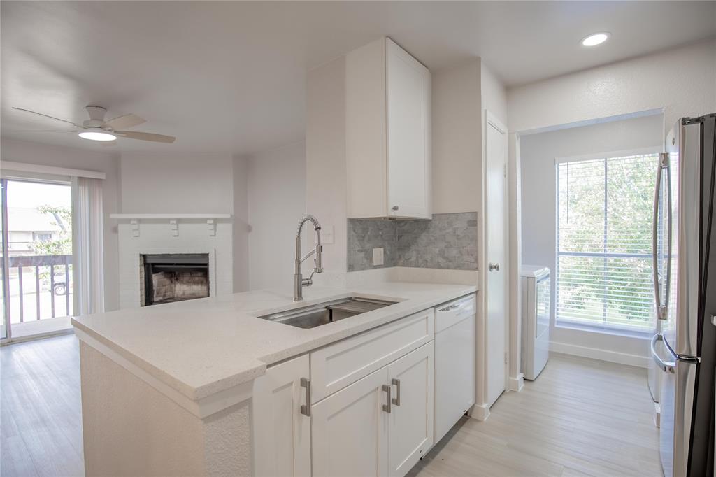 a kitchen with granite countertop a sink a stove and cabinets