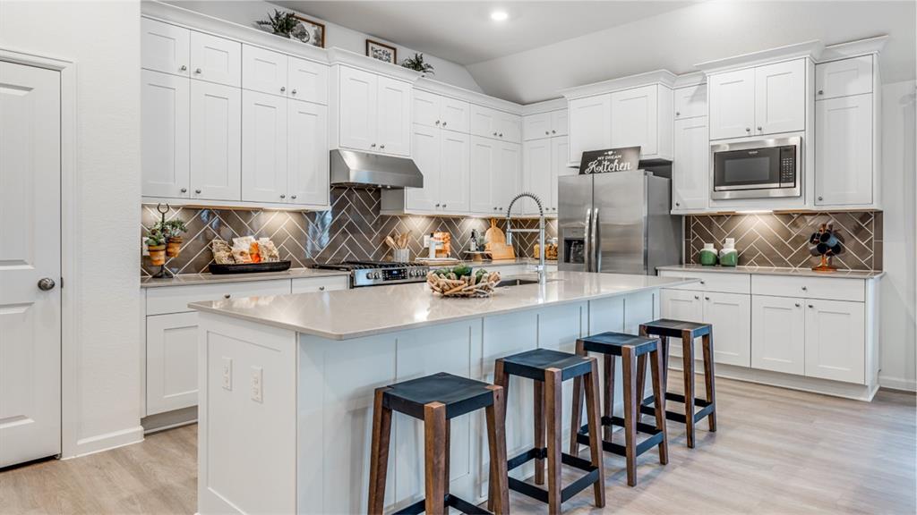 a kitchen with white cabinets and stainless steel appliances