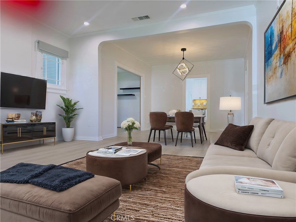 a living room with furniture a dining table and a flat screen tv