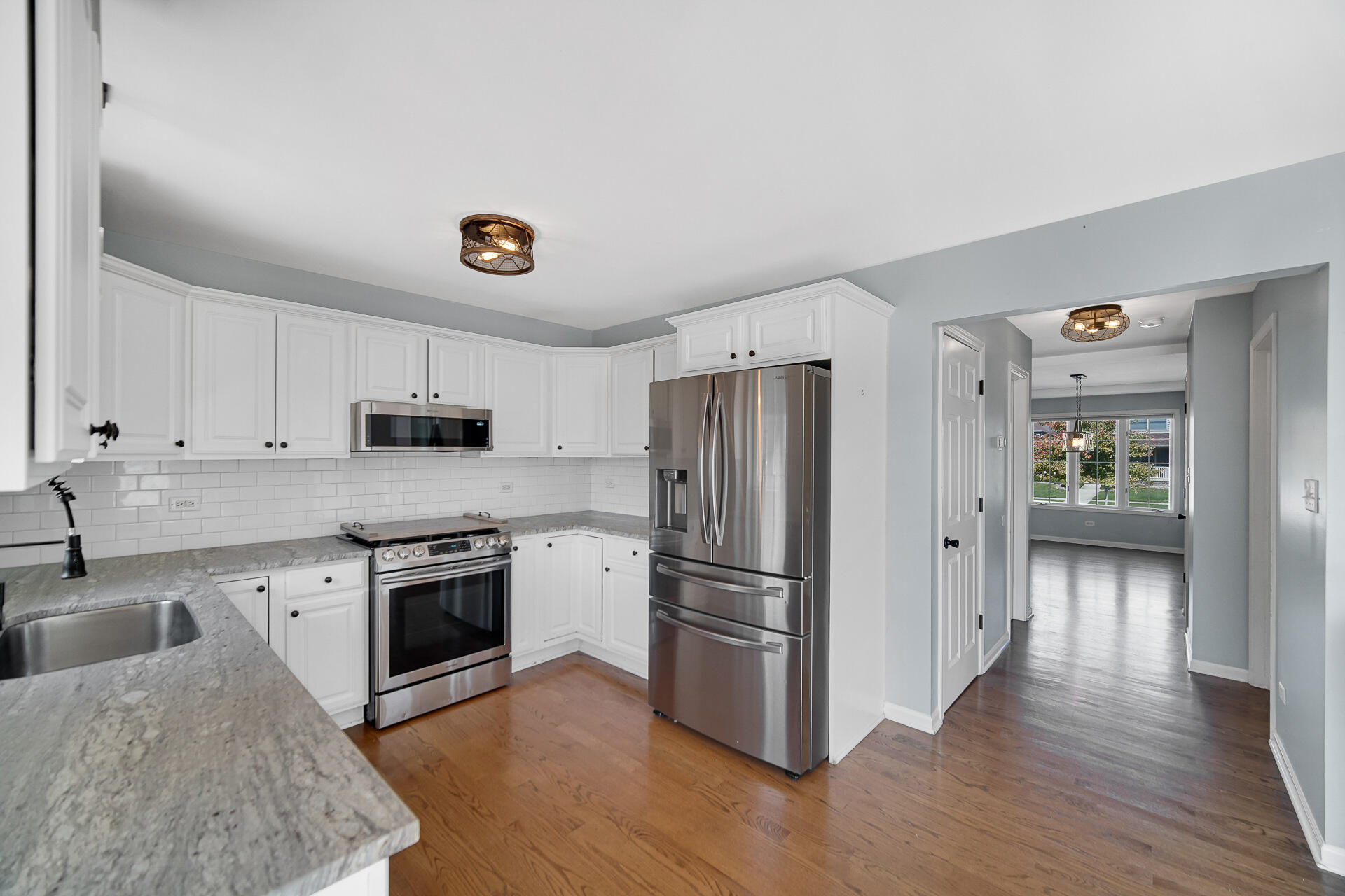 a kitchen with stainless steel appliances granite countertop a refrigerator stove and sink