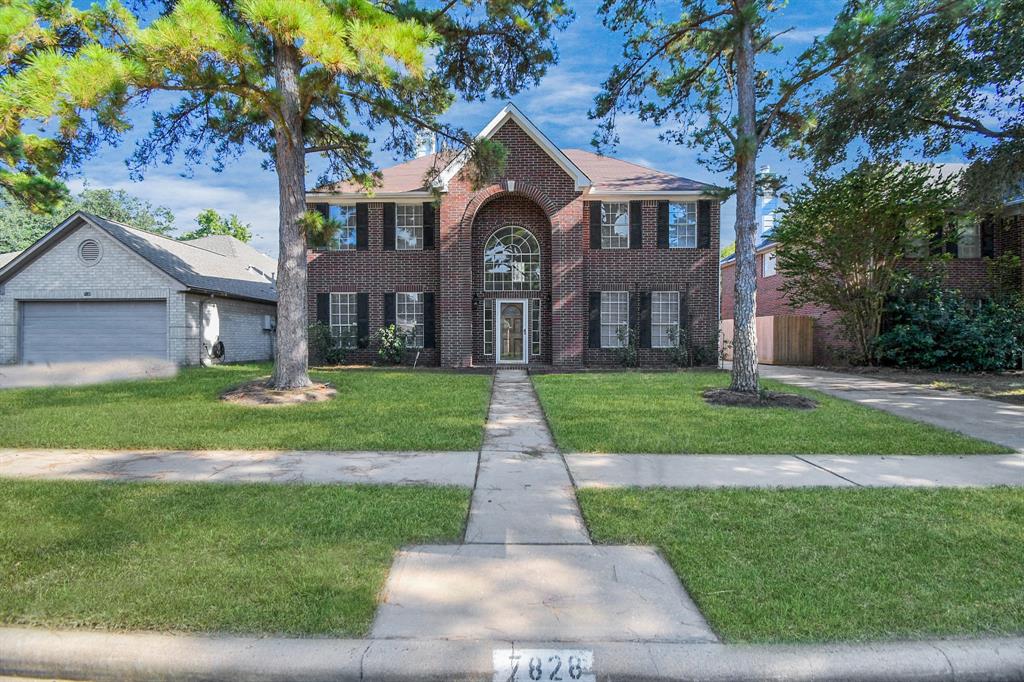 front view of a brick house with a yard