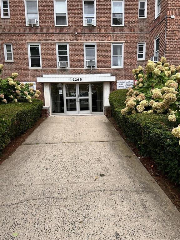 a front view of a building with a garden