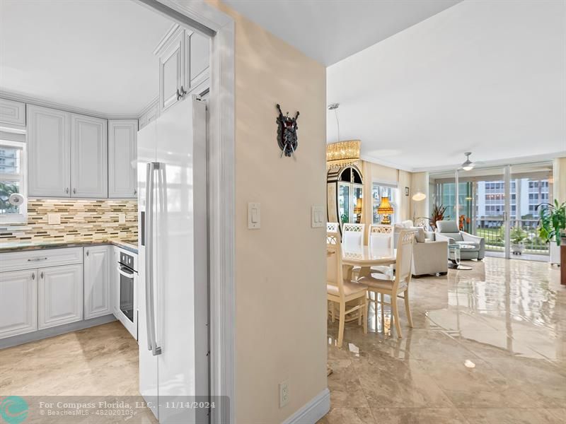 a kitchen with stainless steel appliances kitchen island granite countertop a refrigerator and cabinets