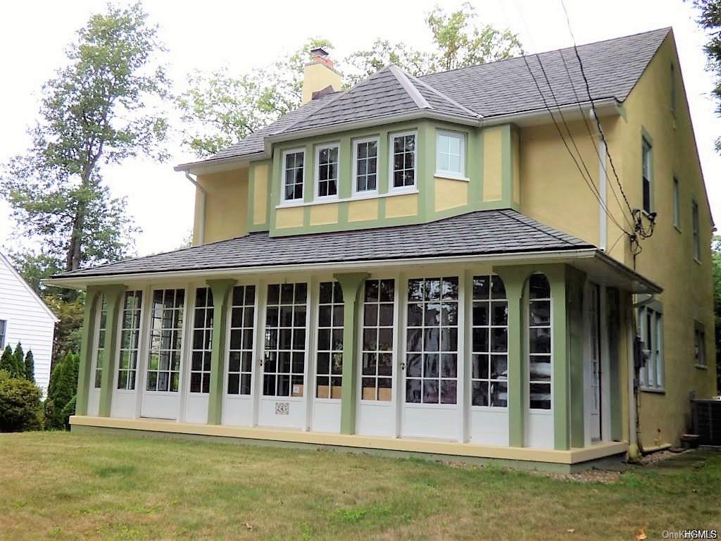 a view of a brick house with large windows and a yard