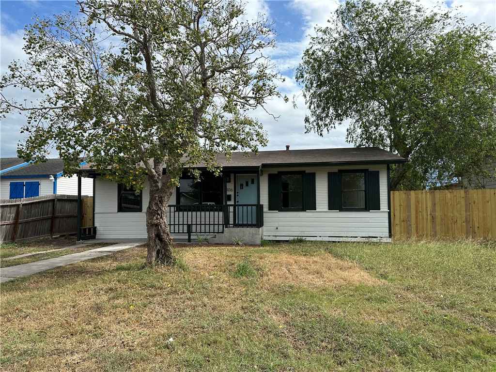 a view of a house with a yard tree and a table