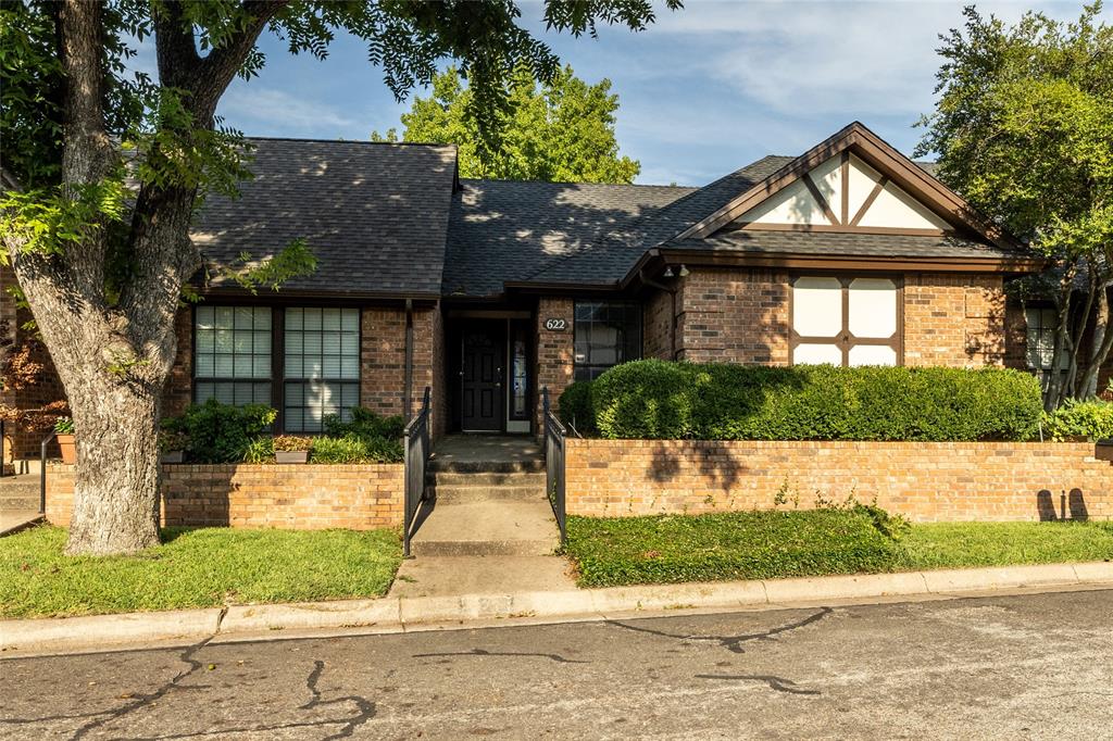 a front view of a house with a yard and potted plants