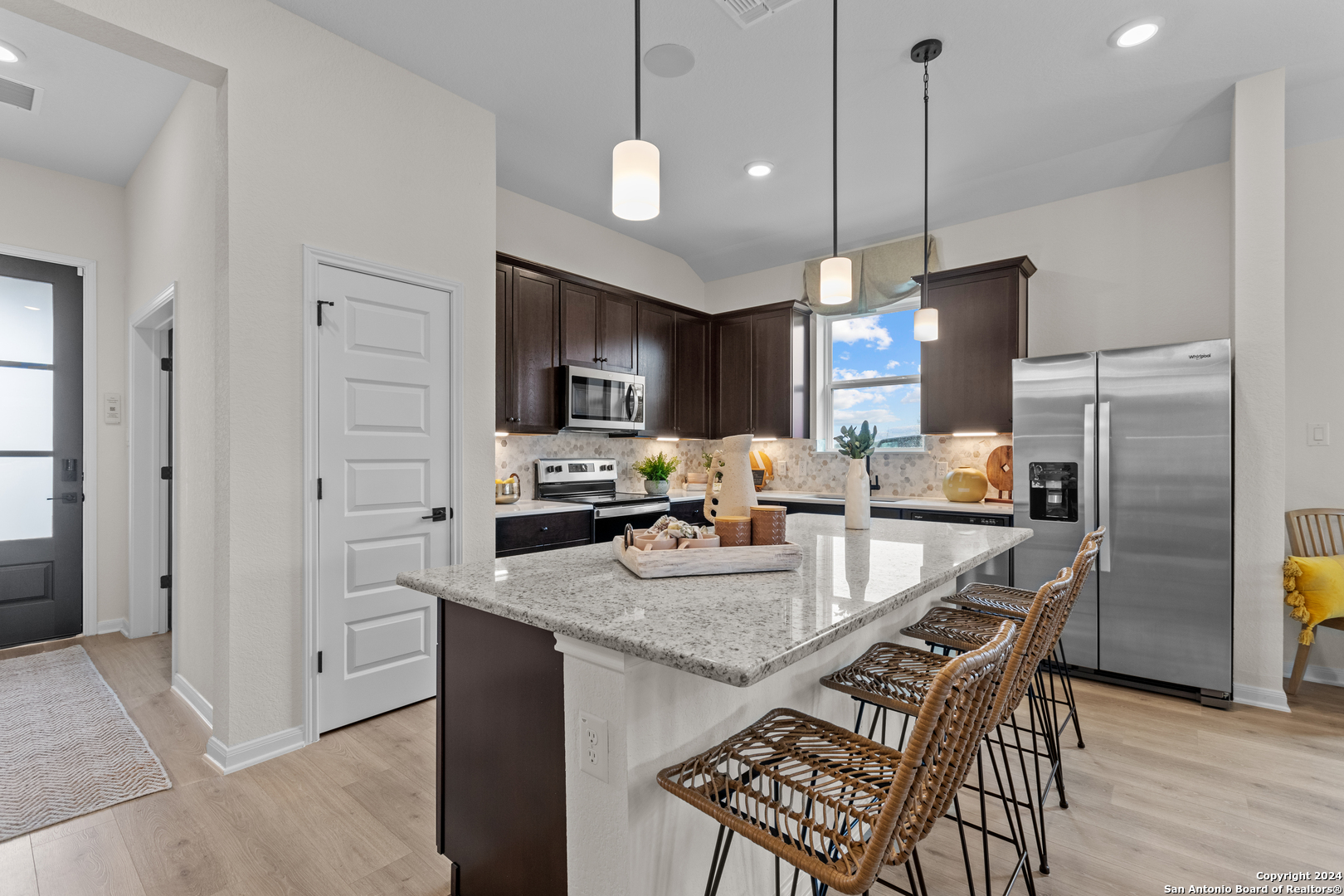 a kitchen with refrigerator a microwave and wooden floor