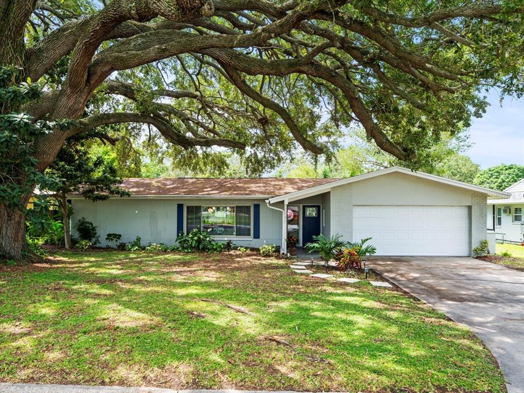 a front view of house with yard and trees around