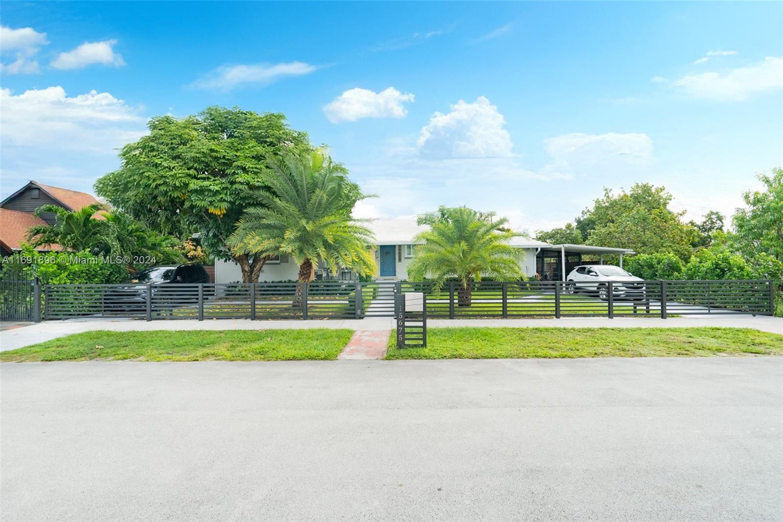 a view of ocean with a big yard and large trees