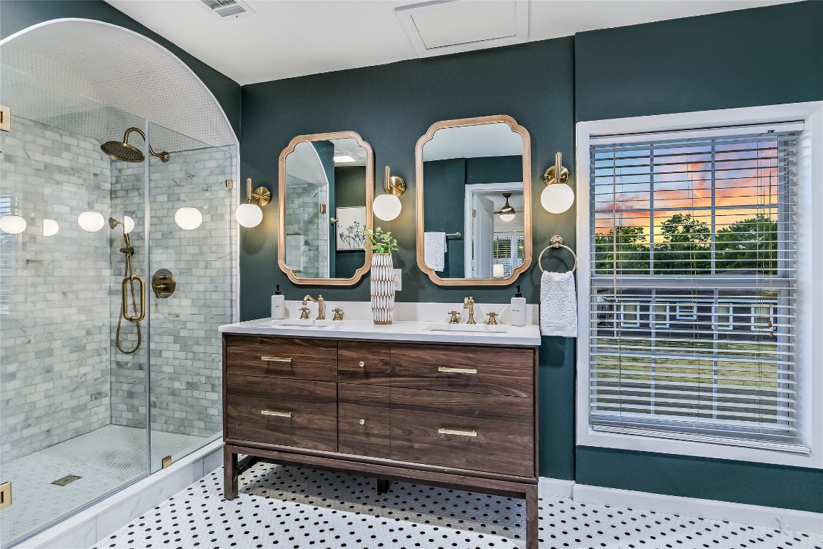 a bathroom with a double vanity sink mirror and shower