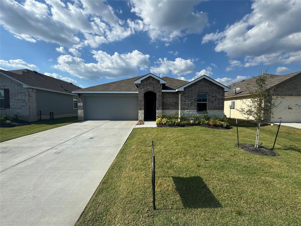 a front view of a house with a yard and garage