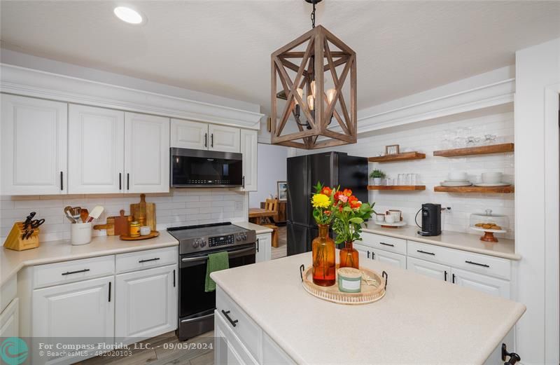 a kitchen with stainless steel appliances granite countertop a sink a stove and a wooden floor