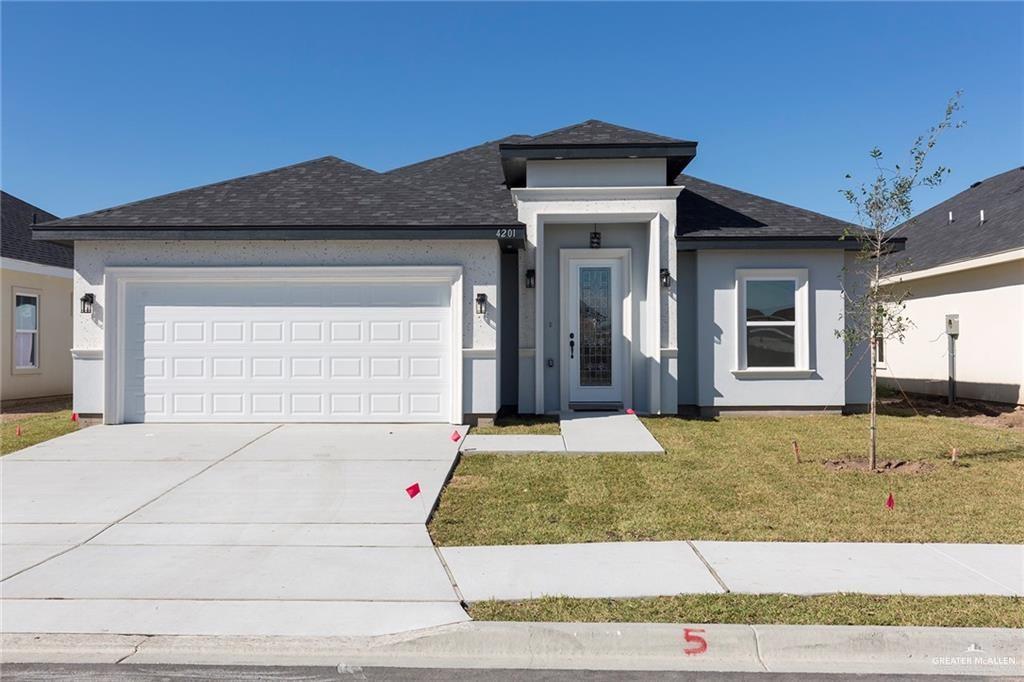 View of front of home featuring a garage and a front lawn