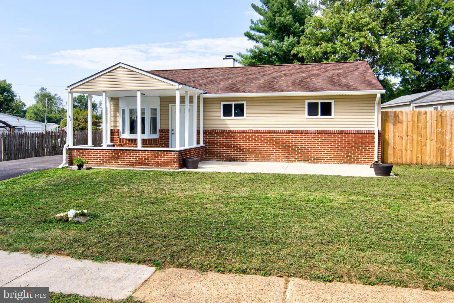 a front view of a house with a yard and trees