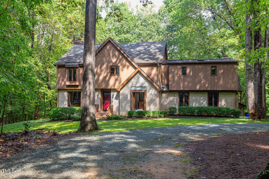 a front view of a house with a yard and trees