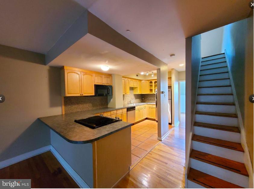 a kitchen view with granite countertop a sink and a refrigerator