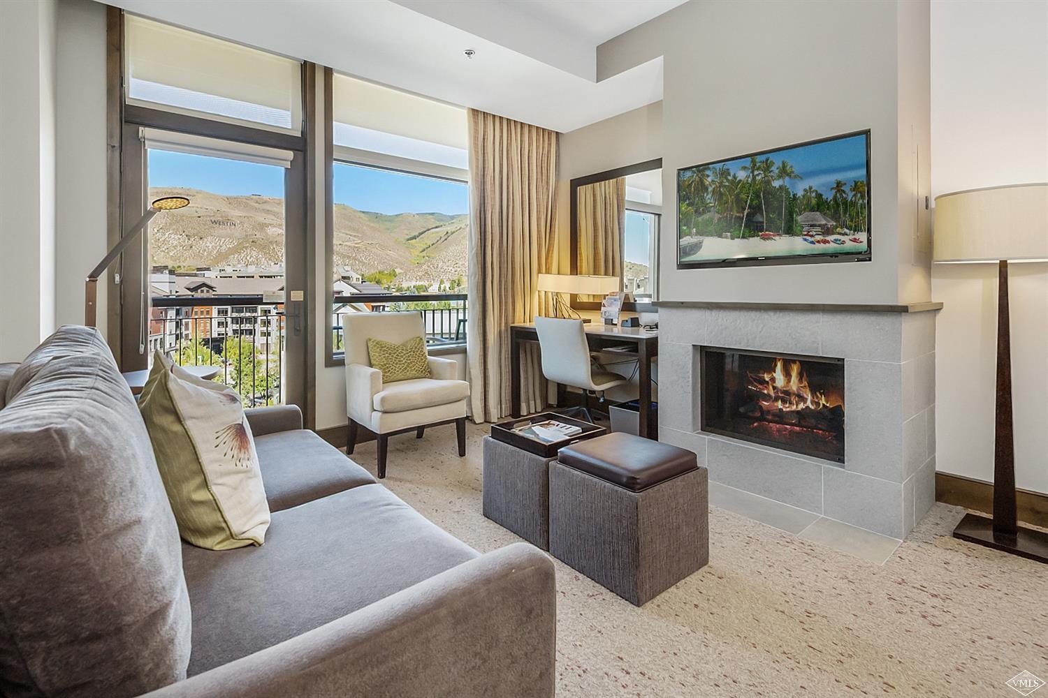 a living room with furniture large window and a fireplace