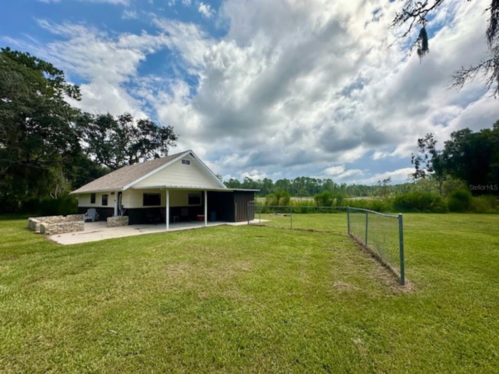 a view of a house with a yard and sitting area