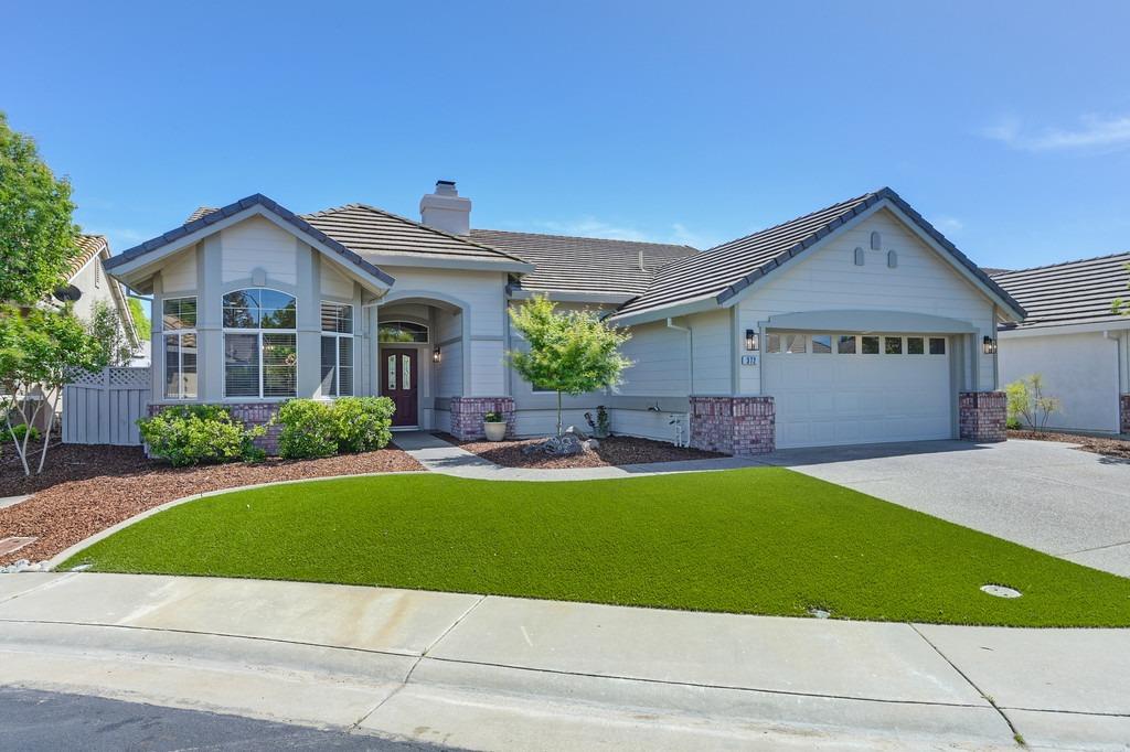 a front view of a house with a garden and yard