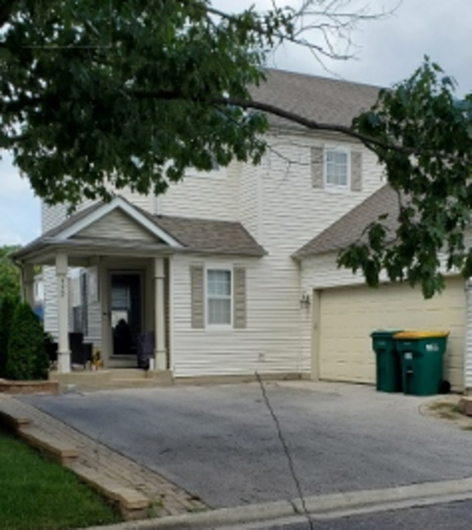 a view of a house with a yard and large tree