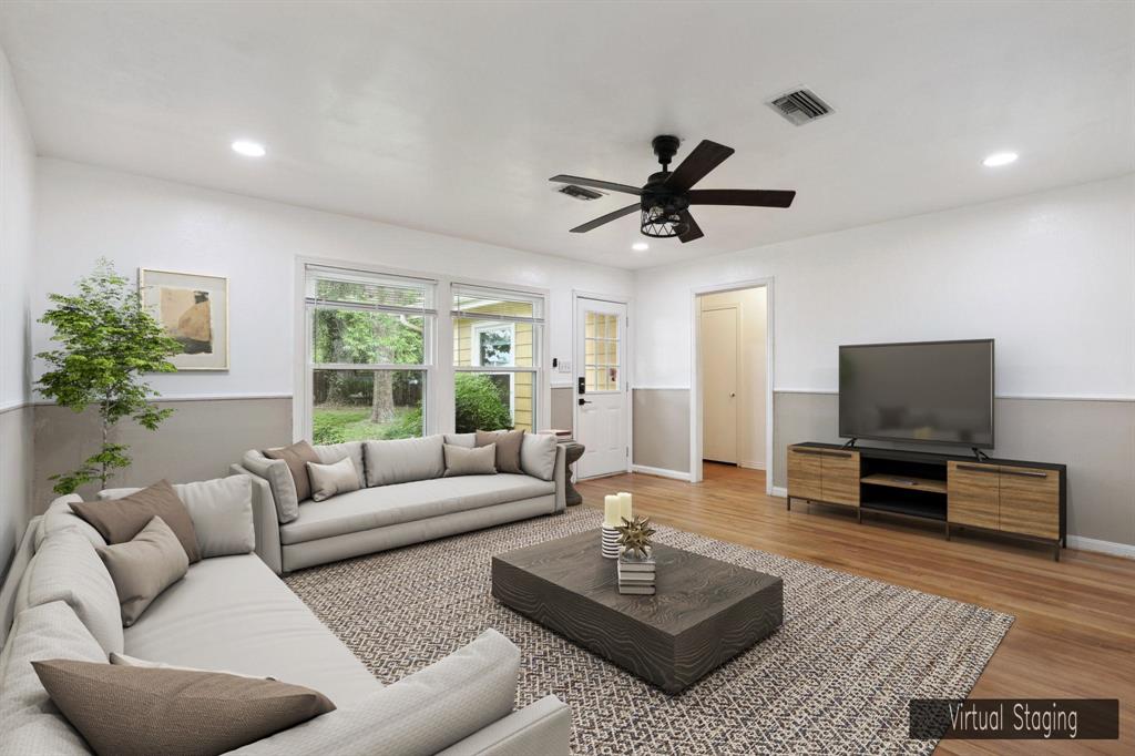 a living room with furniture a window and a flat screen tv