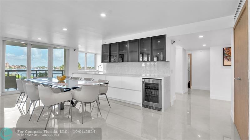 a kitchen with a dining table chairs and refrigerator