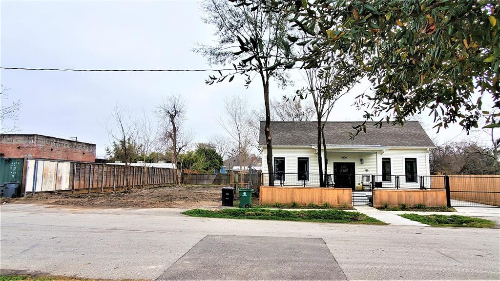 a view of house in front of a big yard with large trees