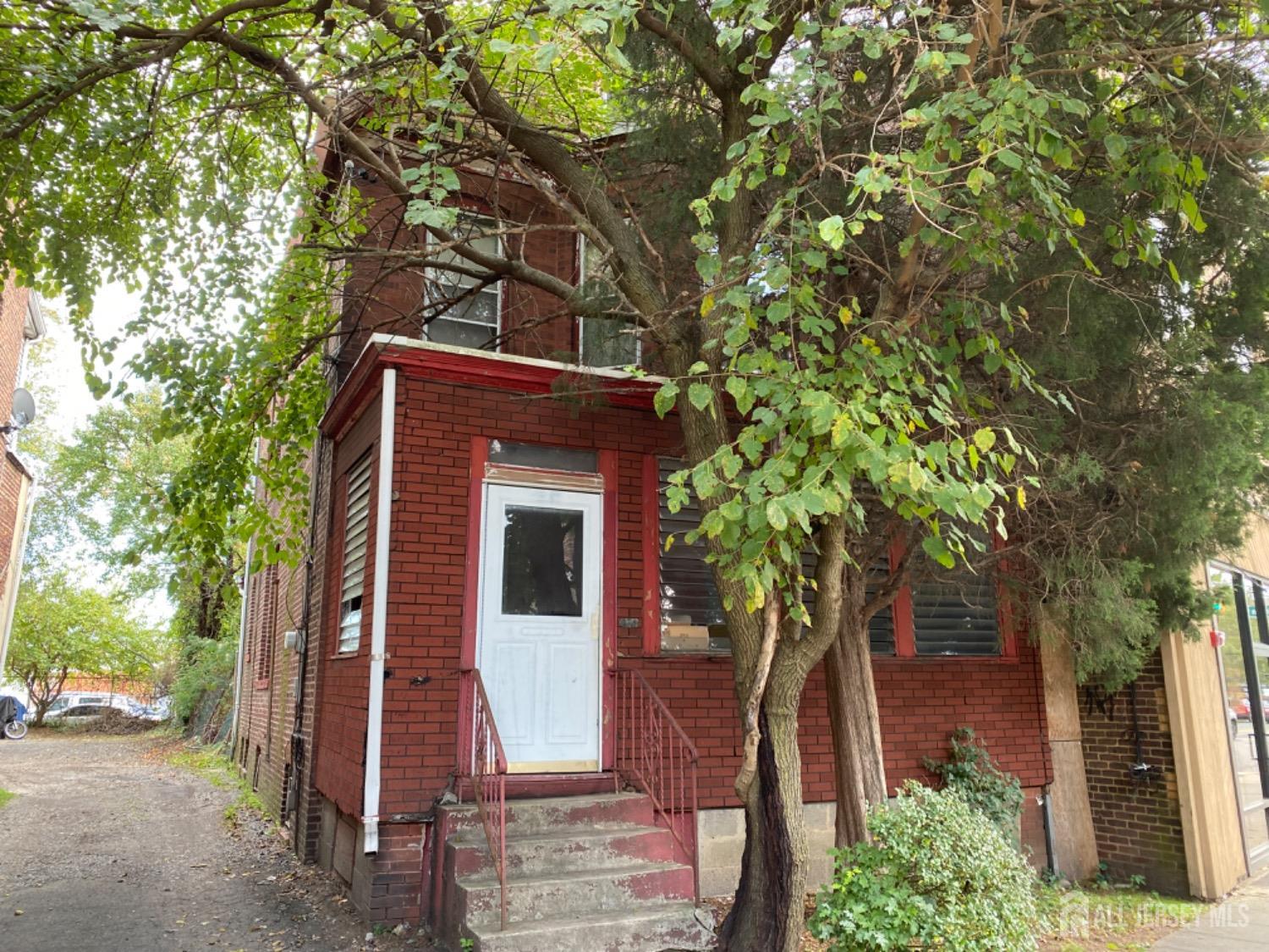 a front view of a house with a tree