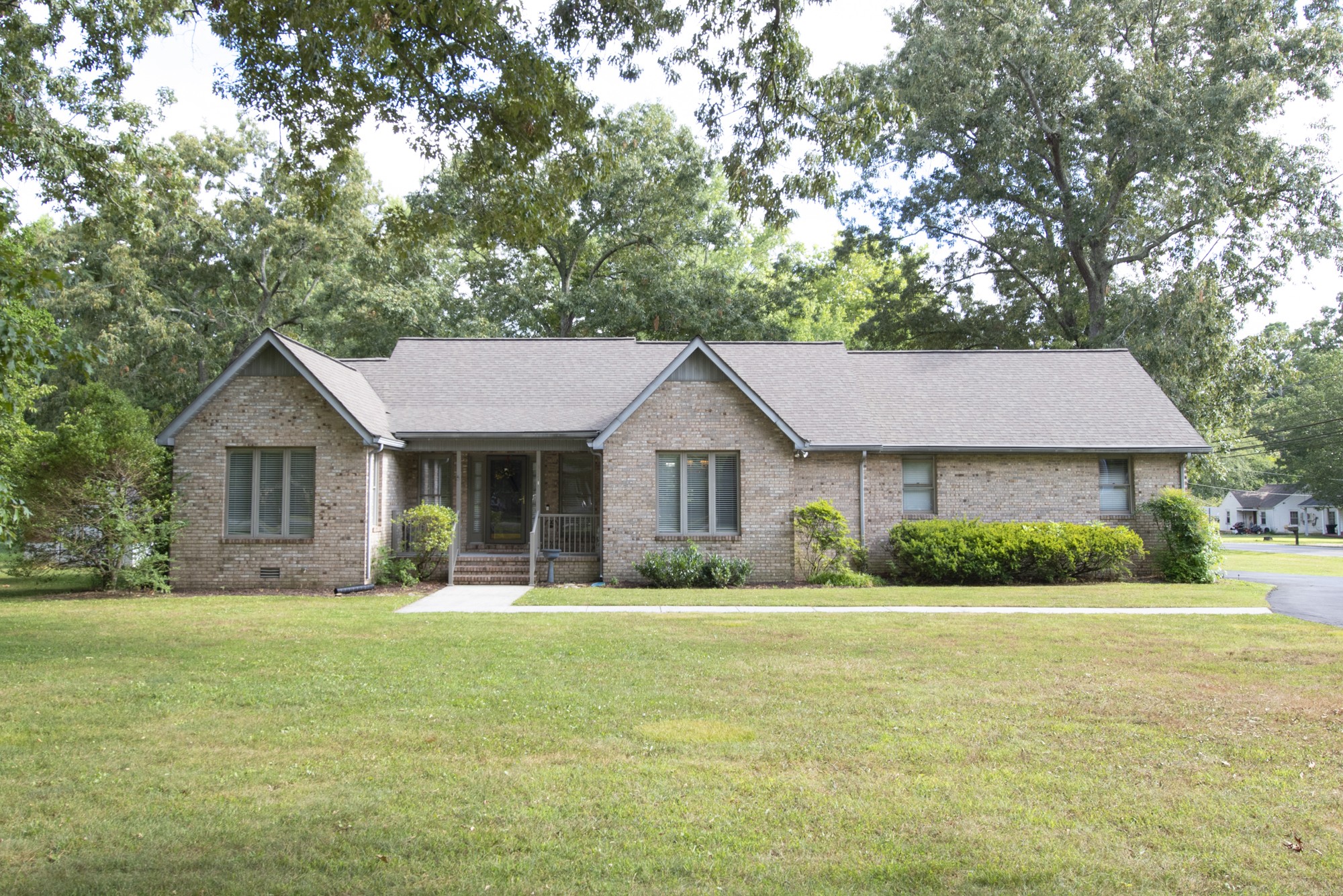 a front view of a house with yard and green space