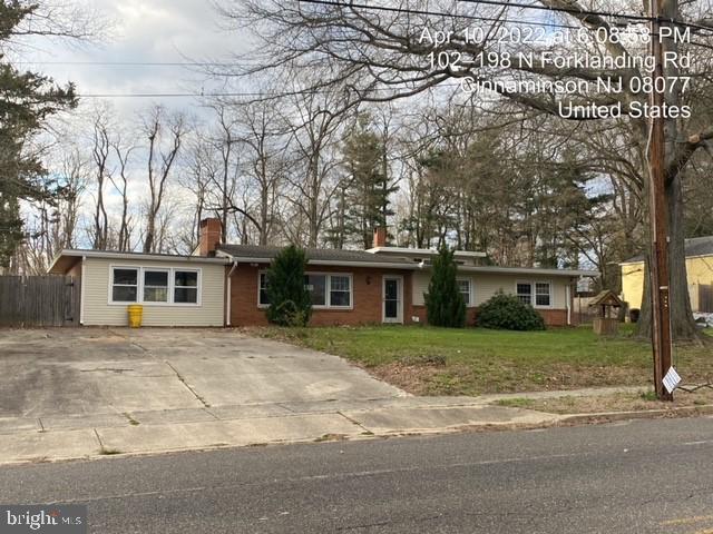 a front view of a house with a yard and trees