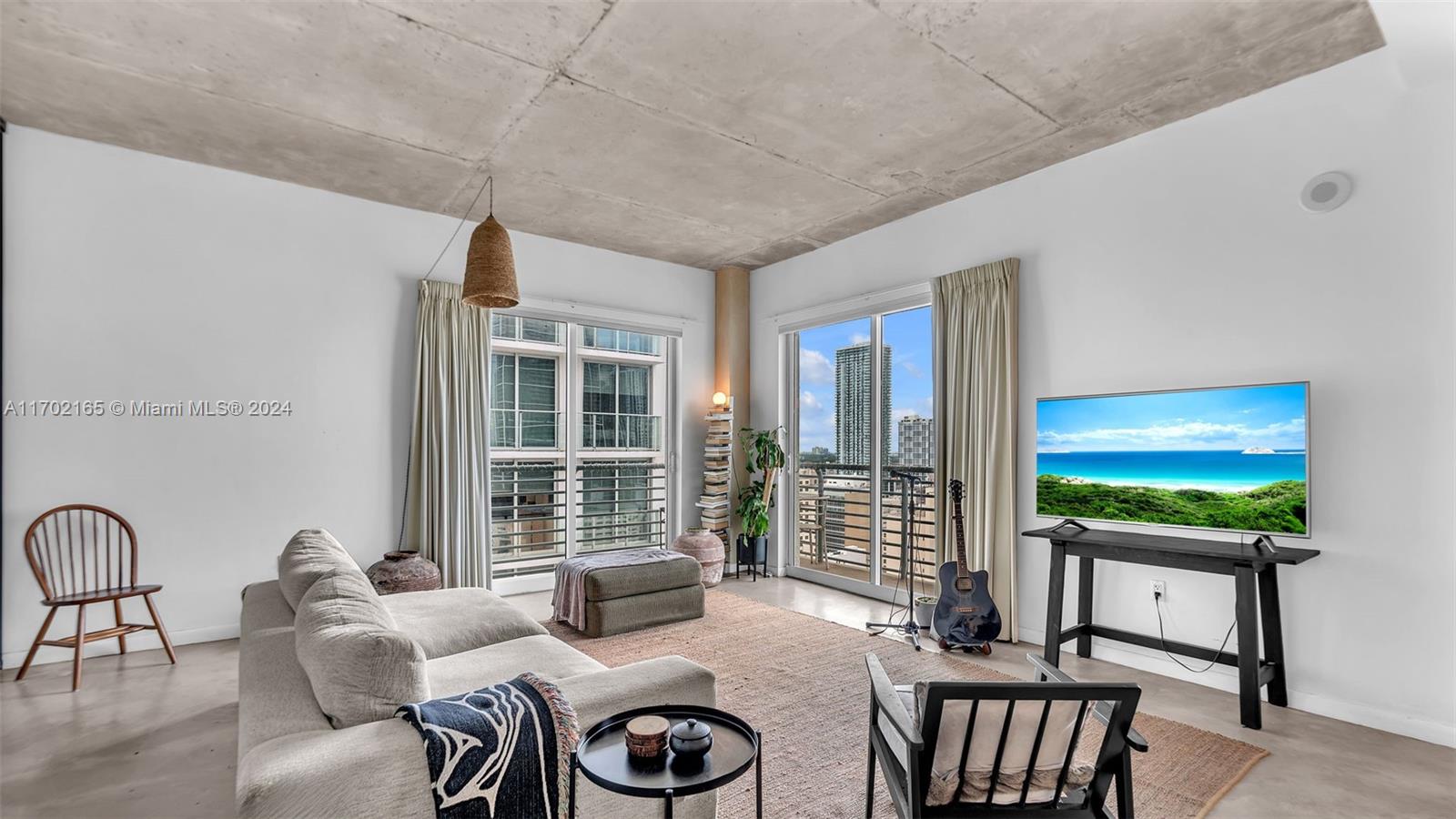 a living room with furniture a flat screen tv and floor to ceiling window