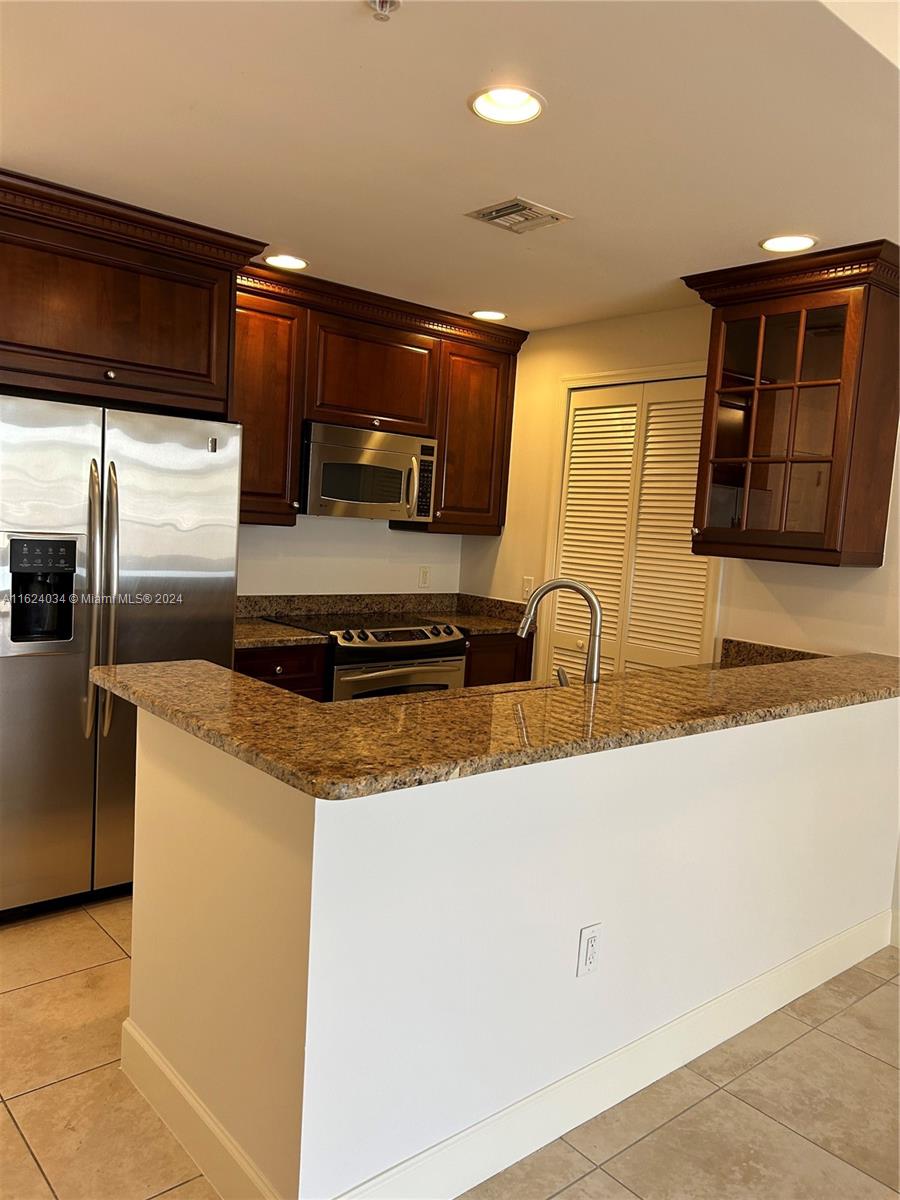 a kitchen with stainless steel appliances granite countertop a sink and a stove