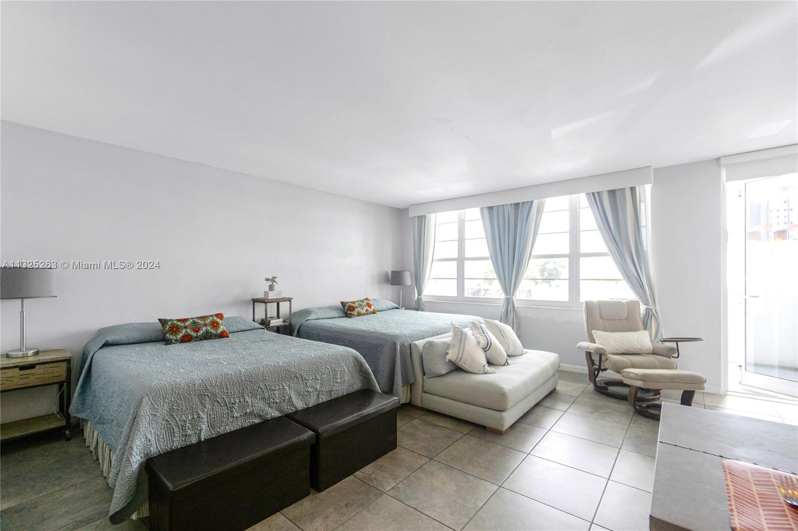 a bedroom with two beds and a large window