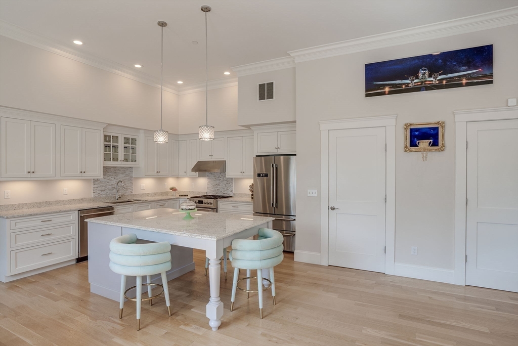 a kitchen with stainless steel appliances a table and chairs in it