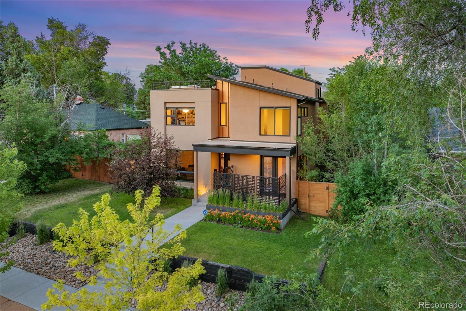 a view of a house with a yard and potted plants