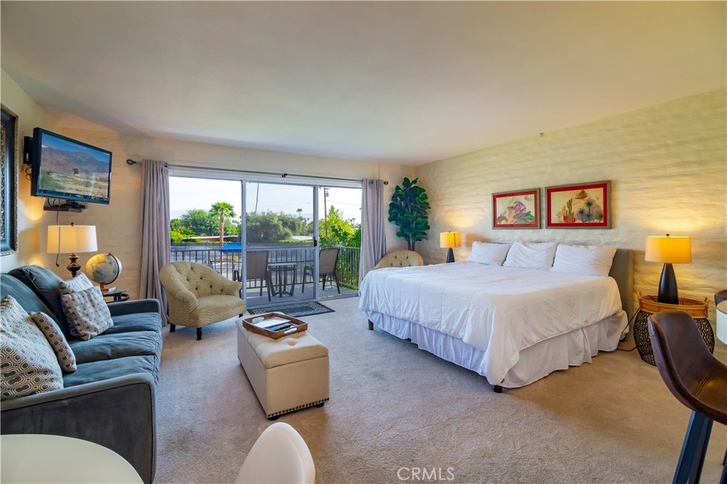 a bedroom with bed couch and window