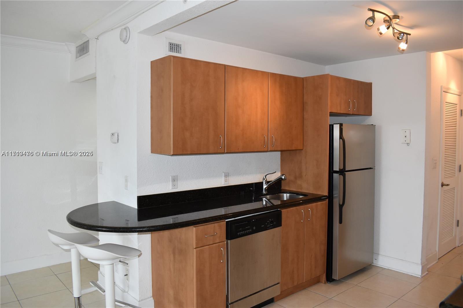 a kitchen with stainless steel appliances granite countertop a refrigerator sink and cabinets